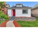 Charming single-Gathering home boasting a bright red door, river rock landscaping, and manicured lawn at 2767 W 38Th Ave, Denver, CO 80211