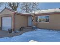 Tan colored ranch home with attached garage and snowy landscaping at 5421 S Sherman St, Littleton, CO 80121