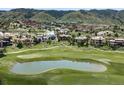 Gorgeous aerial view of a luxury home community built alongside a lush green golf course and pond at 7188 Raphael Ln, Littleton, CO 80125