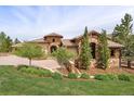 Beautiful stone and stucco home with mature landscaping and a circular driveway at 7188 Raphael Ln, Littleton, CO 80125