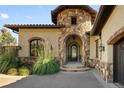 Charming front entrance with a stone archway and an ornate iron door at 7188 Raphael Ln, Littleton, CO 80125