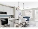 Modern kitchen with sleek countertops, stainless steel appliances, and a stylish island with seating at 8917 Yates Dr, Westminster, CO 80031