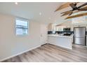 Modern kitchen with stainless steel appliances, white cabinetry, and stylish backsplash, complemented by wood-look floors at 3379 S Eliot St, Englewood, CO 80110