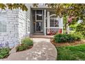 Inviting front porch with walkway, white stone accents, comfortable seating, and lush landscaping at 9478 Burgundy Cir, Highlands Ranch, CO 80126