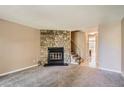 Living room featuring a stone fireplace and carpet flooring at 1342 S Idalia St, Aurora, CO 80017