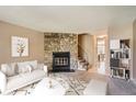 Virtually staged living room with stone fireplace and neutral decor at 1342 S Idalia St, Aurora, CO 80017