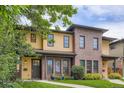 Two-story townhouse with a brick and tan siding, accented by a green lawn at 1916 S Elati St, Denver, CO 80223
