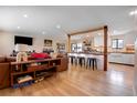 Open-concept living space featuring hardwood floors and seamless flow into the kitchen area with bar seating at 3885 Hoyt St, Wheat Ridge, CO 80033