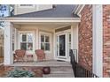 Inviting front porch with cozy seating, decorative shrubbery, and brick facade entrance for welcoming guests at 1011 S Valentia St # 121, Denver, CO 80247