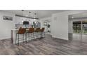 Bright, modern kitchen with stainless steel appliances, quartz countertops, and an island with bar seating at 2203 S Harlan St, Denver, CO 80227