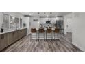Bright, modern kitchen with stainless steel appliances, quartz countertops, and an island with bar seating at 2203 S Harlan St, Denver, CO 80227