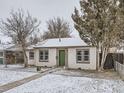 Charming home with a green front door and snow-covered yard provides curb appeal at 1780 Oswego St, Aurora, CO 80010