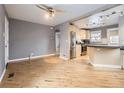 A spacious living room featuring light hardwood floors, neutral gray walls, and open access to the kitchen at 1780 Oswego St, Aurora, CO 80010