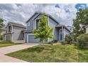 Two-story home with blue siding, well-manicured lawn, and attached garage showcases great curb appeal at 8750 Redwing Ave, Littleton, CO 80126