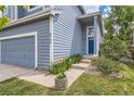 Home's entrance features a blue front door, manicured lawn, and blooming flowers at 8750 Redwing Ave, Littleton, CO 80126