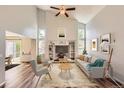 Bright living room features vaulted ceiling, built-in shelves, updated flooring, and a ceiling fan at 8750 Redwing Ave, Littleton, CO 80126