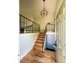 Inviting entryway featuring hardwood floors, staircase with black metal railing, and modern lighting at 15908 E Flora Pl, Aurora, CO 80013