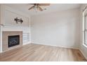 Bright living room with fireplace, built-in shelving, and hardwood floors at 8962 E Otero Pl, Centennial, CO 80112