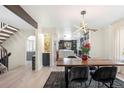 Dining area featuring a modern table, stylish chairs, and an open view into the kitchen at 7591 S Reed Ct, Littleton, CO 80128