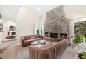 Bright living room with a stone fireplace, high ceilings, comfortable sofas, and natural light at 7591 S Reed Ct, Littleton, CO 80128