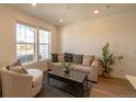 Bright living room with a large window, plush seating, and modern decor at 9152 Gladiola Way # E, Arvada, CO 80005