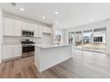 Modern kitchen with stainless steel appliances, white cabinetry, and a large center island at 9692 Cathay St, Commerce City, CO 80022