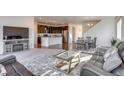 Open-concept living room with modern furnishings, flowing into a spacious kitchen and dining area at 9373 Pitkin St, Commerce City, CO 80022
