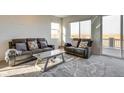 Bright living room with comfortable seating and access to a balcony with scenic views at 9373 Pitkin St, Commerce City, CO 80022