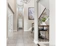 Spacious foyer featuring tile floors, high ceilings, and decorative lighting fixtures at 237 Maplehurst Dr, Highlands Ranch, CO 80126