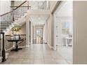Open foyer with staircase, decorative table and decor, and doorway to office space at 237 Maplehurst Dr, Highlands Ranch, CO 80126