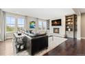 Comfortable living room with fireplace, built-in shelving, and abundant natural light at 237 Maplehurst Dr, Highlands Ranch, CO 80126