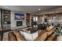 Cozy living room boasts a brick fireplace, custom built-ins, and dark hardwood floors at 237 Maplehurst Dr, Highlands Ranch, CO 80126