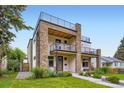 Modern townhouse showcasing a stone facade, balconies, and a rooftop deck at 4455 Tejon St, Denver, CO 80211