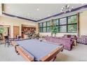 Charming club house with billiard table, sofa, kitchenette, and large windows, perfect for relaxation at 13456 Via Varra # 406, Broomfield, CO 80020