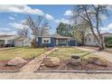Charming blue home featuring well-kept landscaping, stone and a walkway to the front door at 2718 S Hazel Ct, Denver, CO 80236