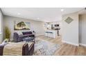 Sunlit living room featuring hardwood floors and comfortable seating, with an open view of the modern kitchen at 4507 W 2Nd Ave, Denver, CO 80219