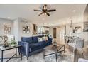 Open-concept living room with hardwood floors, modern furnishings, and seamless flow into the dining and kitchen areas at 11885 W Katherine Ave, Lakewood, CO 80401