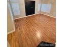 Spacious bedroom with wood floors and three large windows for ample natural light at 6973 Summerset Ave, Longmont, CO 80504