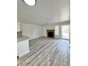 Bright, open-concept living room featuring a modern fireplace, wood floors and a kitchen with granite countertop at 912 S Dearborn Way # 3, Aurora, CO 80012