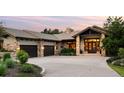 Inviting home exterior featuring stone accents, dark wood garage doors, and a spacious driveway at 786 International Isle Dr, Castle Rock, CO 80108