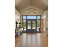 Grand foyer with hardwood floors, a stunning chandelier, and a view to the outdoor landscape at 786 International Isle Dr, Castle Rock, CO 80108