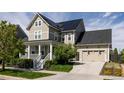 Charming two-story home with a covered porch, well-maintained lawn, and solar panels on the roof at 6072 Chester St, Denver, CO 80238