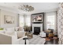 Bright living room with fireplace, ceiling fan, neutral color palette, and large windows at 6072 Chester St, Denver, CO 80238