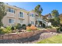 Beautiful backyard with a stone retaining wall, green grass, and a patio under a covered deck at 3337 W 113Th Ave, Westminster, CO 80031