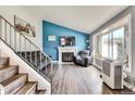 Bright living room featuring a fireplace, large window, and modern decor at 8483 Sandreed Cir, Parker, CO 80134