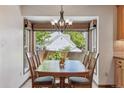 Cozy dining area with a large window, wooden table, and stylish chandelier at 7312 S Moore Ct, Littleton, CO 80127