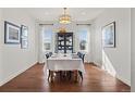 Bright dining room with hardwood floors, large windows, and a table set for a meal at 26531 E Calhoun Pl, Aurora, CO 80016