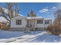 Charming ranch home with snowy front yard and walkway to the entrance at 3500 W 55Th Ave, Denver, CO 80221