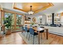 Open dining area with wood floors, large windows, and a stylish light fixture at 9041 Eastridge Rd, Golden, CO 80403