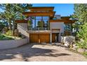 Striking modern home with a brick driveway, large windows, and beautiful wood accents at 9041 Eastridge Rd, Golden, CO 80403